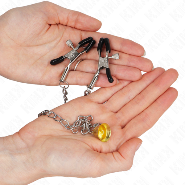 Due pinze per capezzoli Kink Nipple Grip unite da una catena con un campanellino dorato