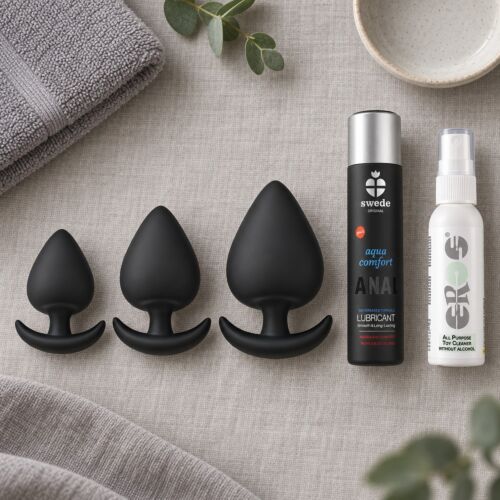 Kit di dilatazione anale progressiva con tre plug in silicone – scena d'atmosfera (immagine generata con IA)